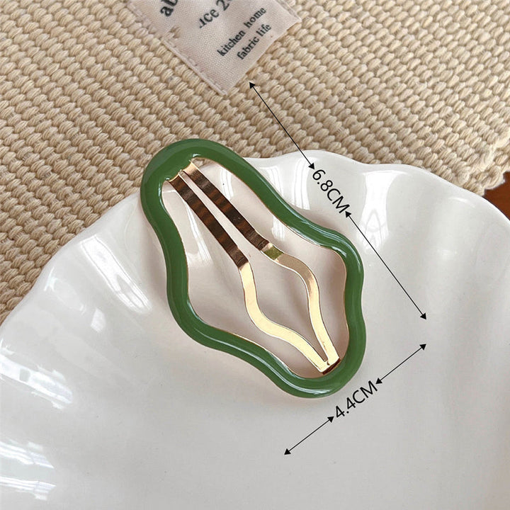 "Molnformade hårklämmor för kvinnor i olika färger, tillverkade i metall och plast, perfekt för stil och funktion."