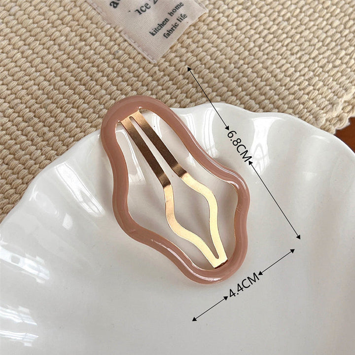 "Molnformade hårklämmor för kvinnor i olika färger, tillverkade i metall och plast, perfekt för stil och funktion."