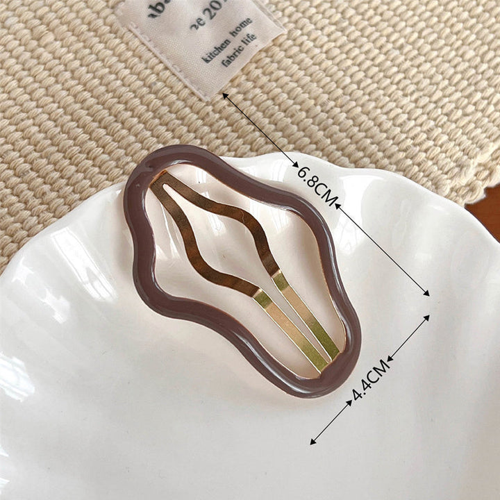"Molnformade hårklämmor för kvinnor i olika färger, tillverkade i metall och plast, perfekt för stil och funktion."