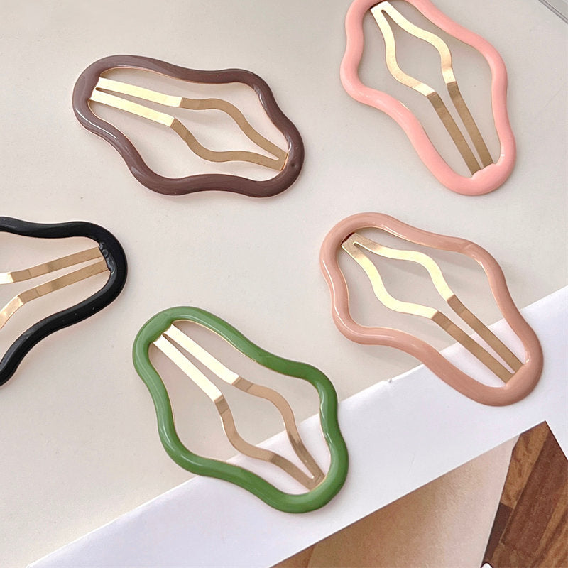 "Molnformade hårklämmor för kvinnor i olika färger, tillverkade i metall och plast, perfekt för stil och funktion."