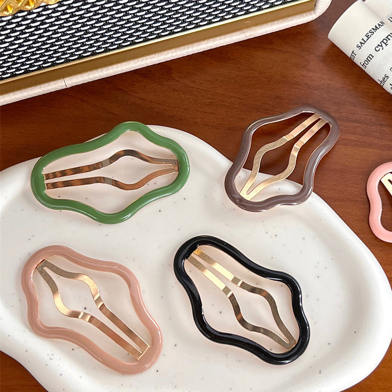 "Molnformade hårklämmor för kvinnor i olika färger, tillverkade i metall och plast, perfekt för stil och funktion."