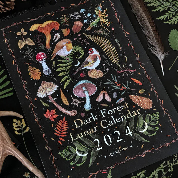 "Mörk Skog Månkalender 2024 med magiska illustrationer av skogsvarelser och botaniska motiv."