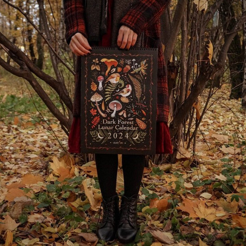 "Mörk Skog Månkalender 2024 med magiska illustrationer av skogsvarelser och botaniska motiv."