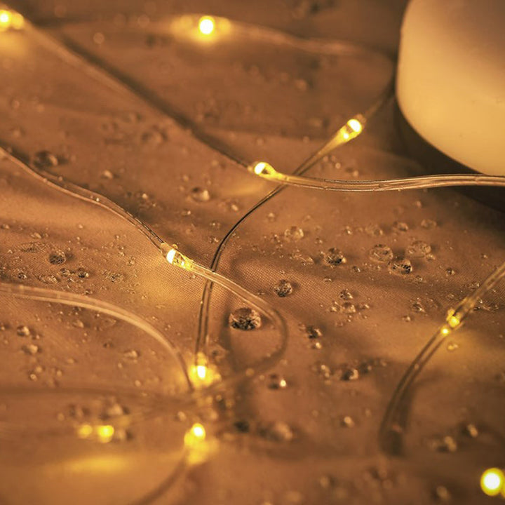 Multifunktionell bärbar campinglampa med IP67-skydd, USB-laddning, lädersnöre och ljusbälte för utomhusbruk.