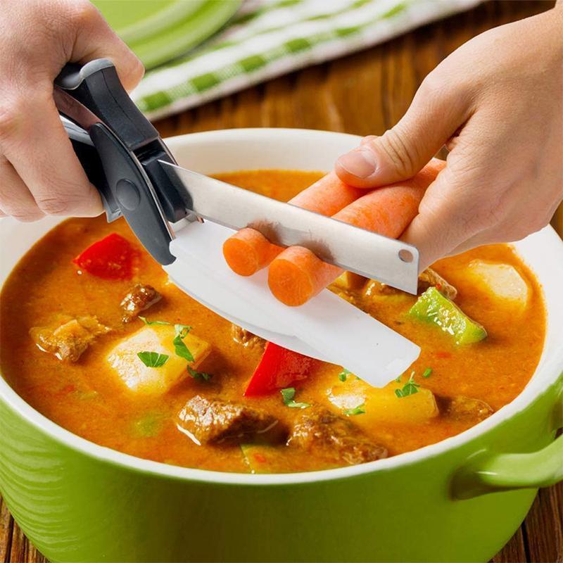 "Multifunktionell grönsaksax med rostfritt stålblad och svart handtag, inbyggd skärbräda för enkel skärning av mat."
