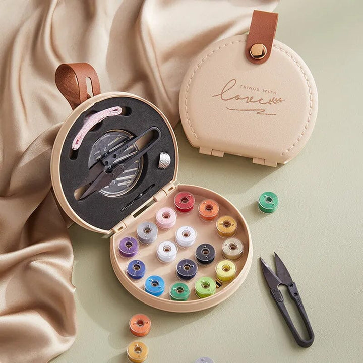 "Multifunktionell handhållen sömnadssats i beige och grön med nålar och trådar i en kompakt, lätt design."