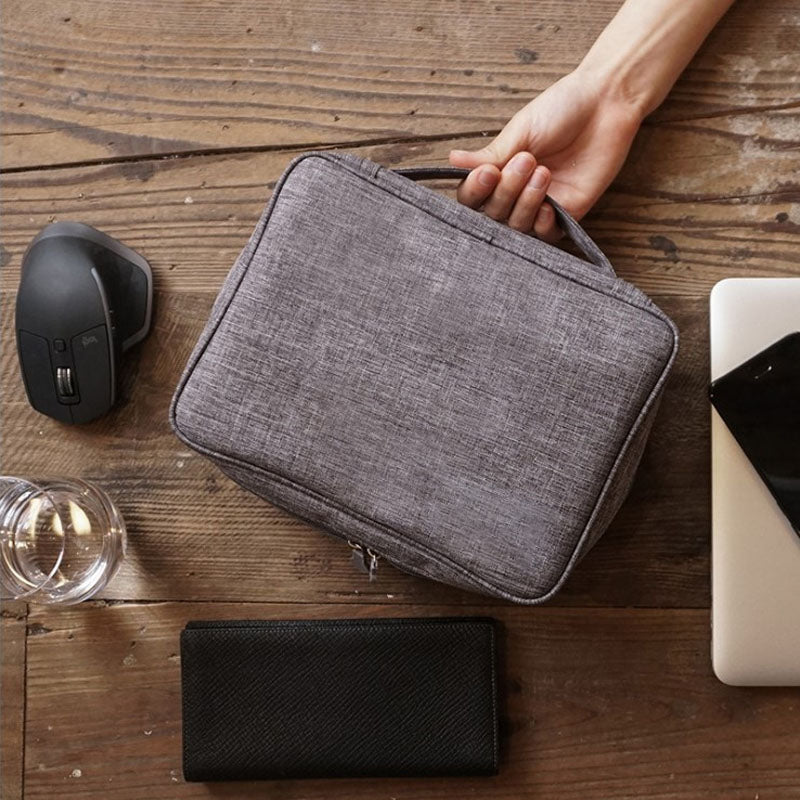 "Multifunktionell kabelförvaringspåse i vattentätt tyg med nätfickor, elastiska öglor för kablar och tillbehör."