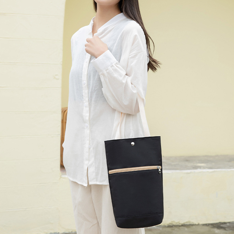 "Multifunktionell somrig damväska, svart polyester och linne, perfekt för fritid och resor. Rymmer dagliga saker."