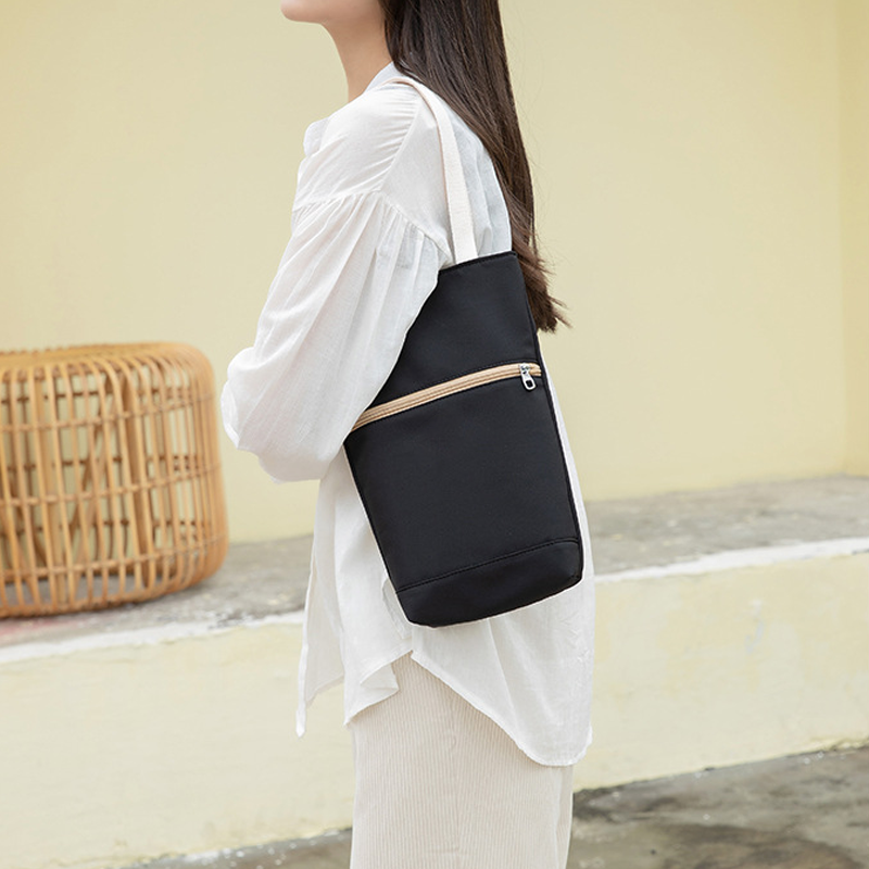 "Multifunktionell somrig damväska, svart polyester och linne, perfekt för fritid och resor. Rymmer dagliga saker."