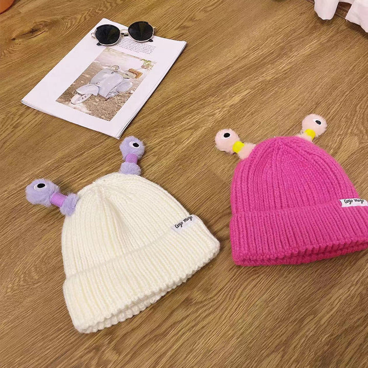 "Mysig vinterstickad mössa för barn och vuxna med monsterdesign och stora ögon i olika färger."
