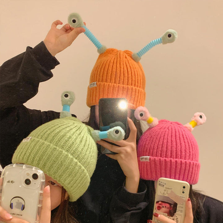 "Mysig vinterstickad mössa för barn och vuxna med monsterdesign och stora ögon i olika färger."