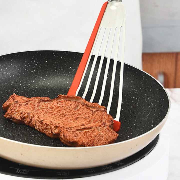 "Nonstick spatelvändare i rostfritt stål och svart silikon, elegant design, perfekt för ägg och pannkakor i köket."