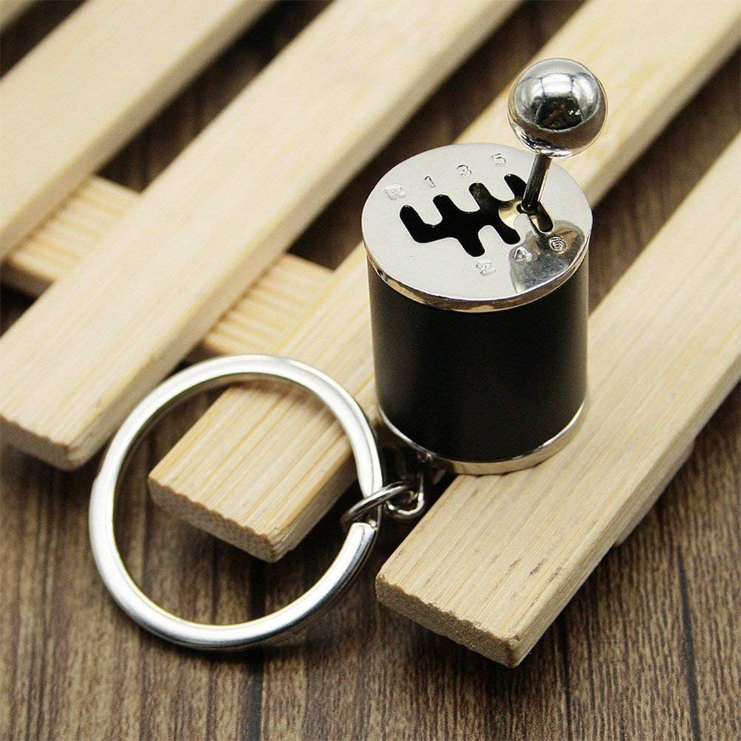 "Nyckelring med manuell växelspak i metall, realistisk design med sex växlar, perfekt för bilentusiaster."