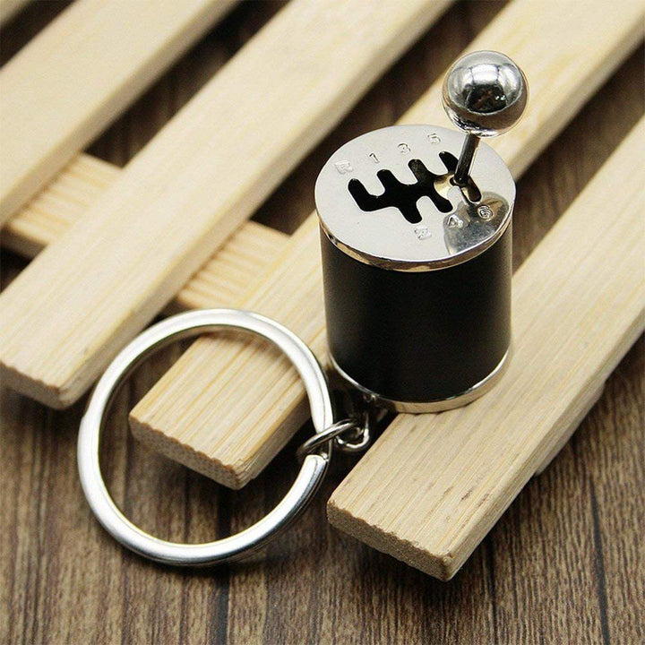 "Nyckelring med manuell växelspak i metall, realistisk design med sex växlar, perfekt för bilentusiaster."