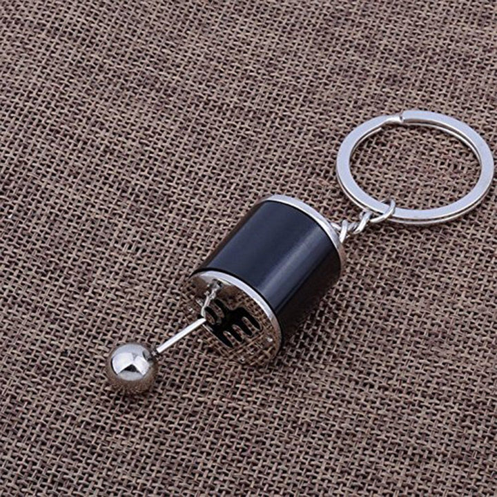 "Nyckelring med manuell växelspak i metall, realistisk design med sex växlar, perfekt för bilentusiaster."