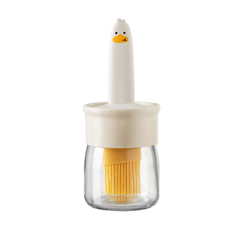"Oljedispenser med söt ankformad silikonborste för grill, i beige och orange, perfekt för matlagning."