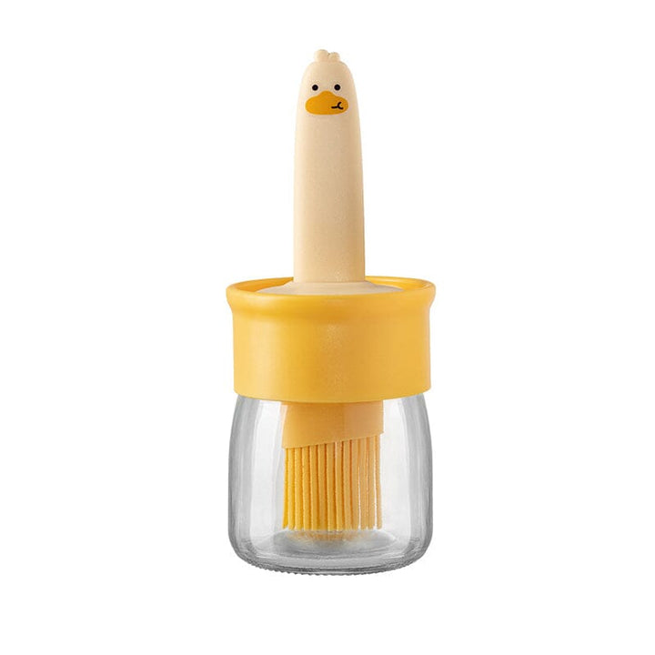 "Oljedispenser med söt ankformad silikonborste för grill, i beige och orange, perfekt för matlagning."