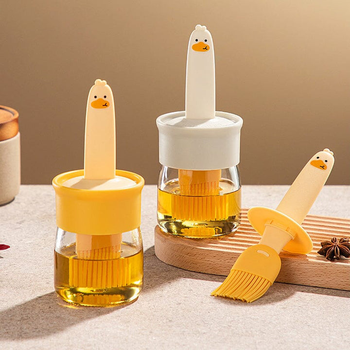 "Oljedispenser med söt ankformad silikonborste för grill, i beige och orange, perfekt för matlagning."