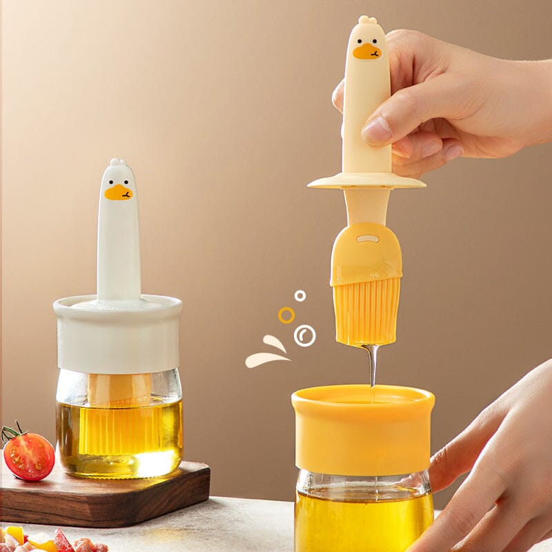 "Oljedispenser med söt ankformad silikonborste för grill, i beige och orange, perfekt för matlagning."