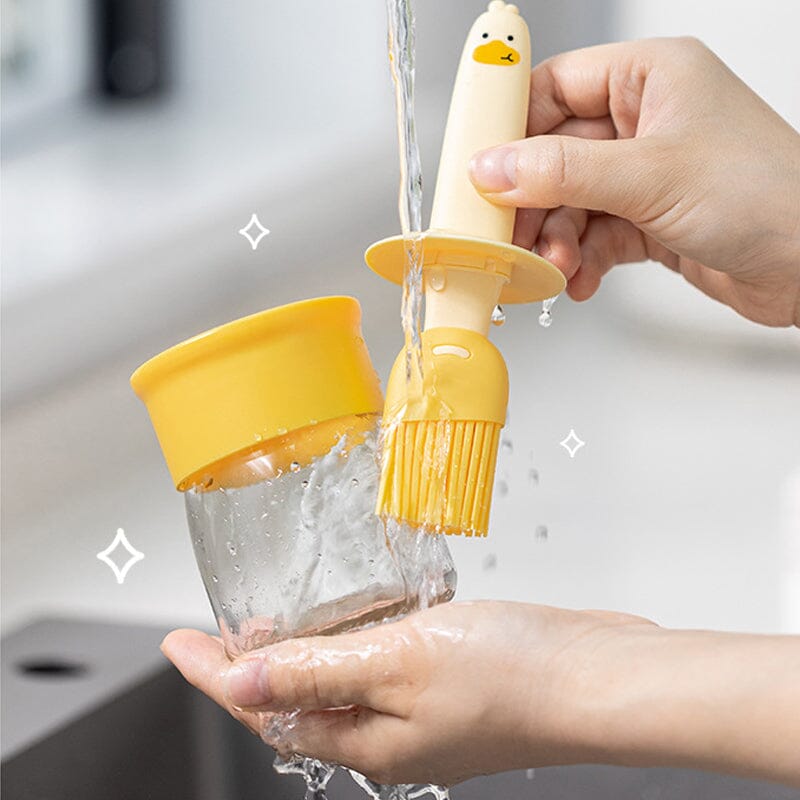 "Oljedispenser med söt ankformad silikonborste för grill, i beige och orange, perfekt för matlagning."