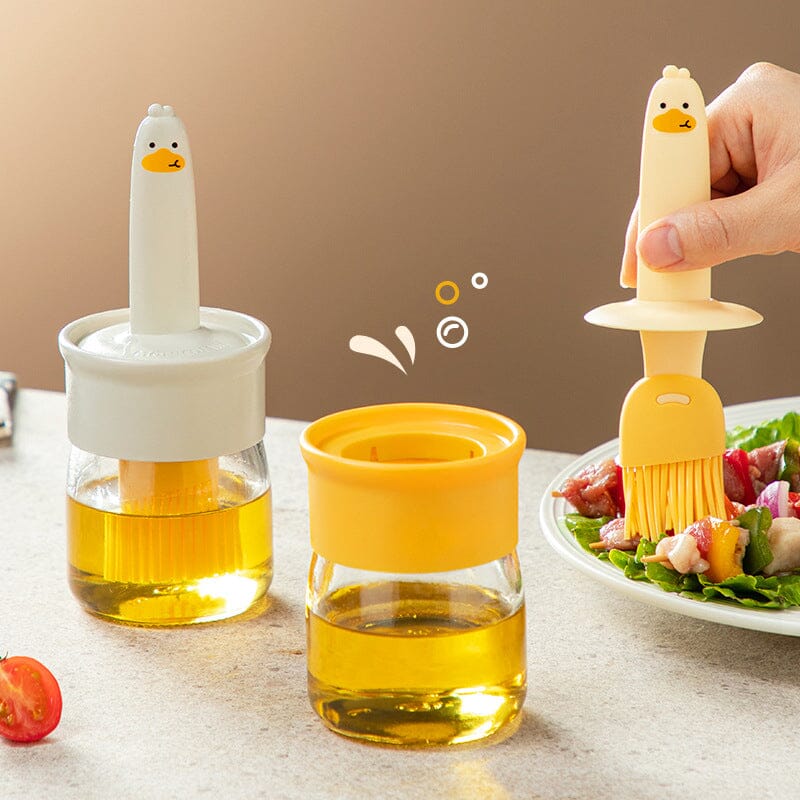"Oljedispenser med söt ankformad silikonborste för grill, i beige och orange, perfekt för matlagning."