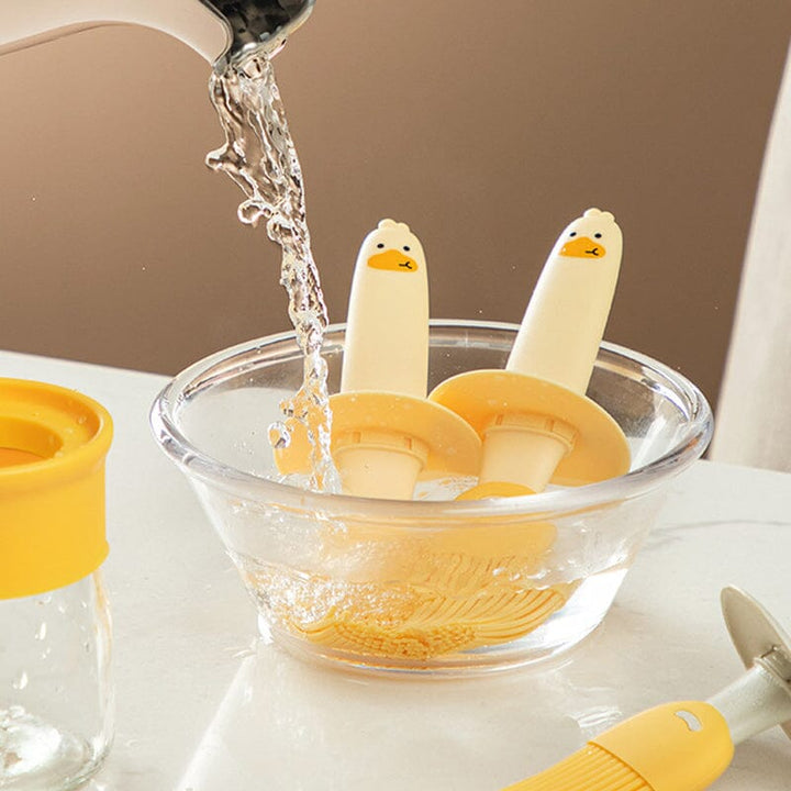 "Oljedispenser med söt ankformad silikonborste för grill, i beige och orange, perfekt för matlagning."