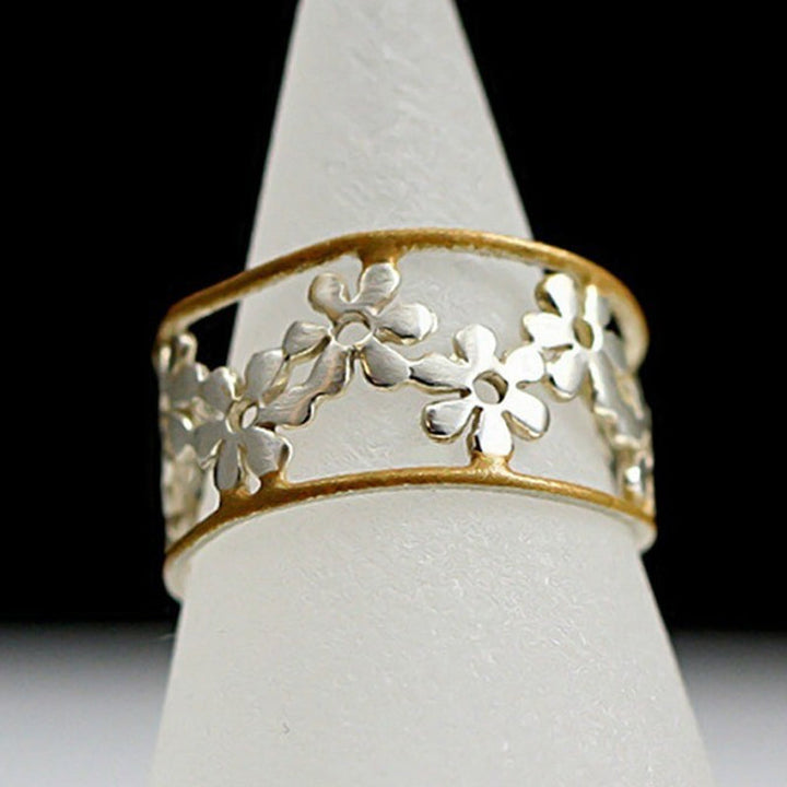Oregelbunden ihålig tusensköna ring för kvinnor, justerbar design i legering, elegant och handgjord accessoar.