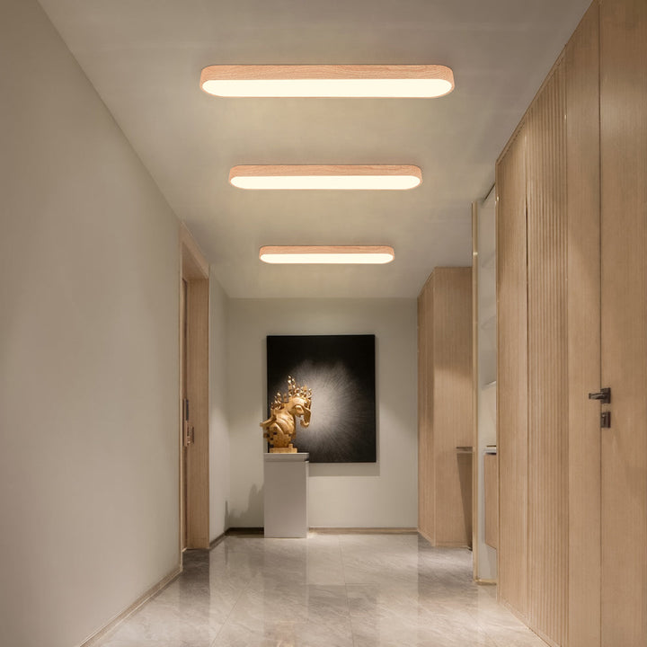 Nordisk oval LED takbelysning med vacker träfinish, ger varmt ljus till ditt hem.