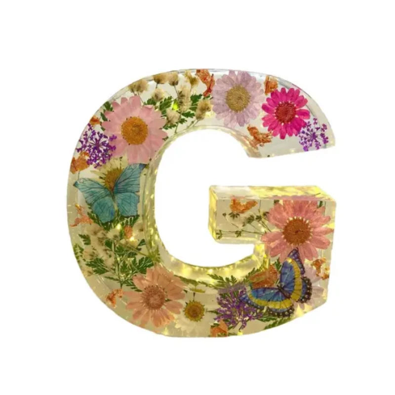 LED-nattlampa med valfri bokstav och inbäddade blommor i harts, ger en personlig och mysig känsla.