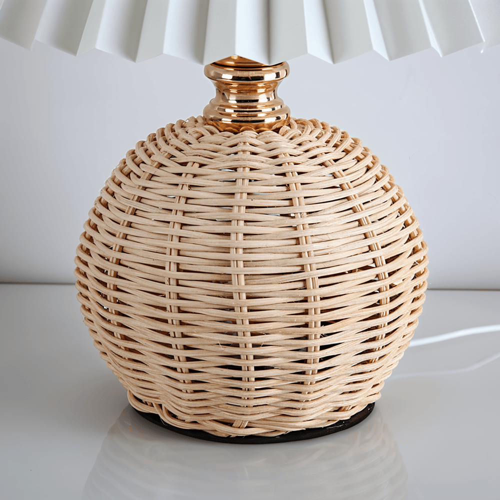 Varm belysning från plisserad bordslampa med retro rotting, perfekt för vardagsrum.