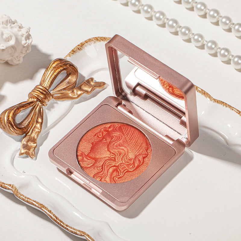 "Präglad puderrougepalett med naturlig glöd, elegant design, subtil skimmer och nyanser rosa till apelsin för alla hudtoner."