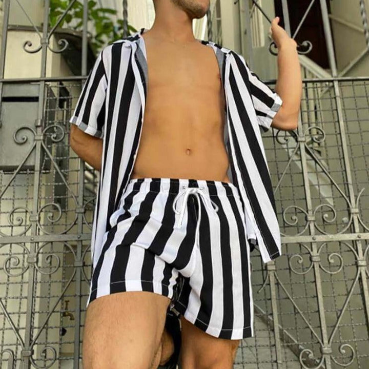 Man i flowigt randigt sommarset, tvådelat med kortärmad topp & shorts, idealiskt för aktiv fritid.