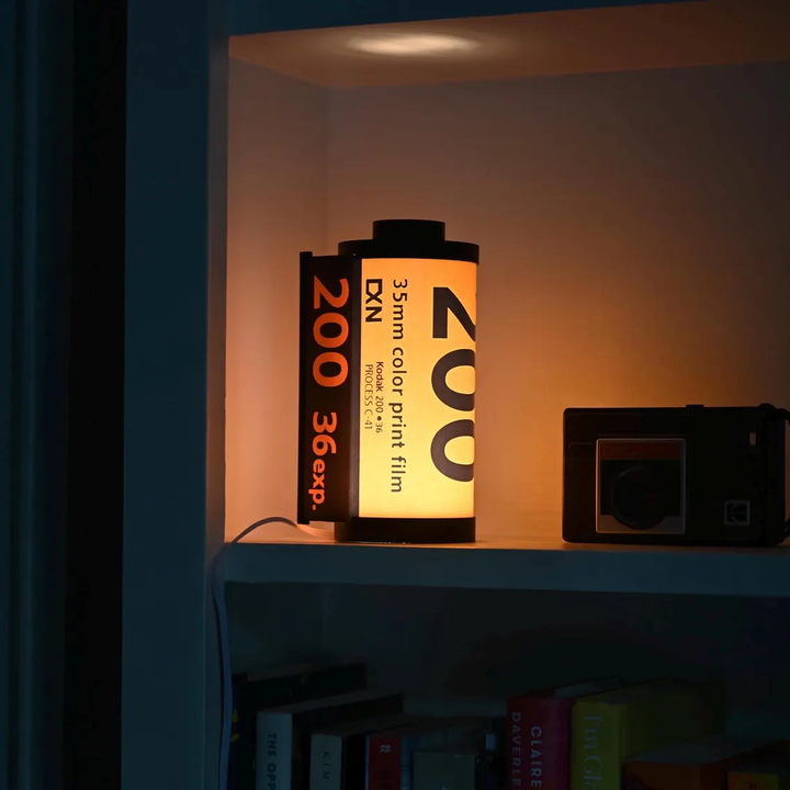 RetroGlow lampa formad som en filmkassett, ger mysig belysning i retrostil. Perfekt vintage inredningsdetalj.