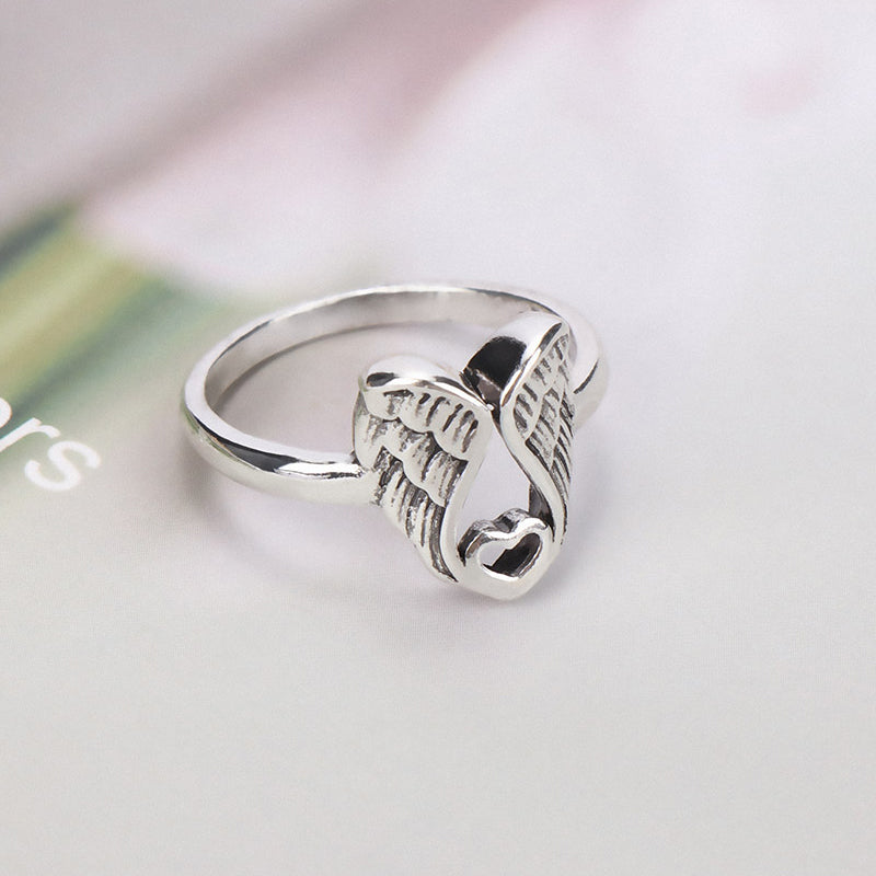 "Ring för kvinnor med detaljerad ängelvingar och hjärtdesign i mässing, elegant accessoar med subtil betydelse."