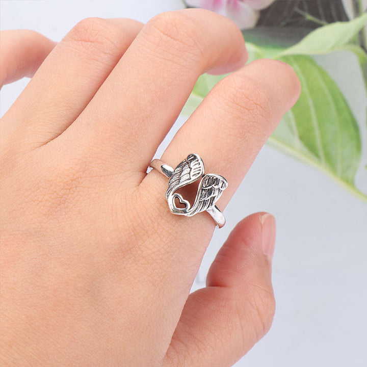 "Ring för kvinnor med detaljerad ängelvingar och hjärtdesign i mässing, elegant accessoar med subtil betydelse."