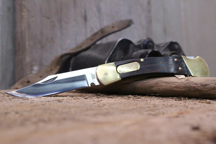 Ergonomiskt handtag på robust fällkniv, ger säkert grepp för jakt och friluftsliv. Pålitligt vildmarksverktyg.