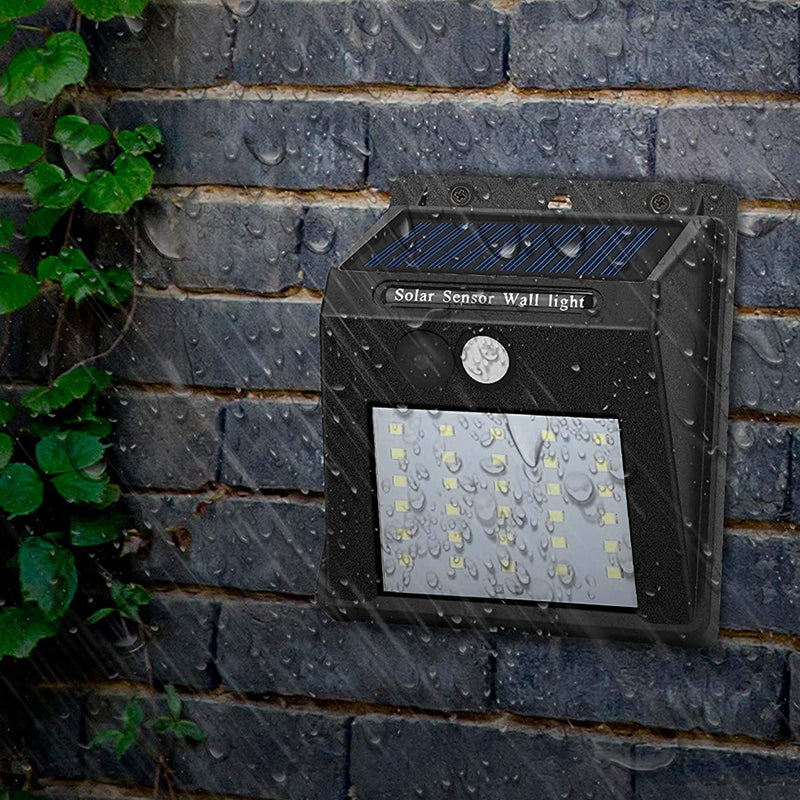 "Rörelsesensor LED-lampa utomhus IP65, solcellsdriven med 30 LED, robust svart design, perfekt för trädgårdsbelysning."