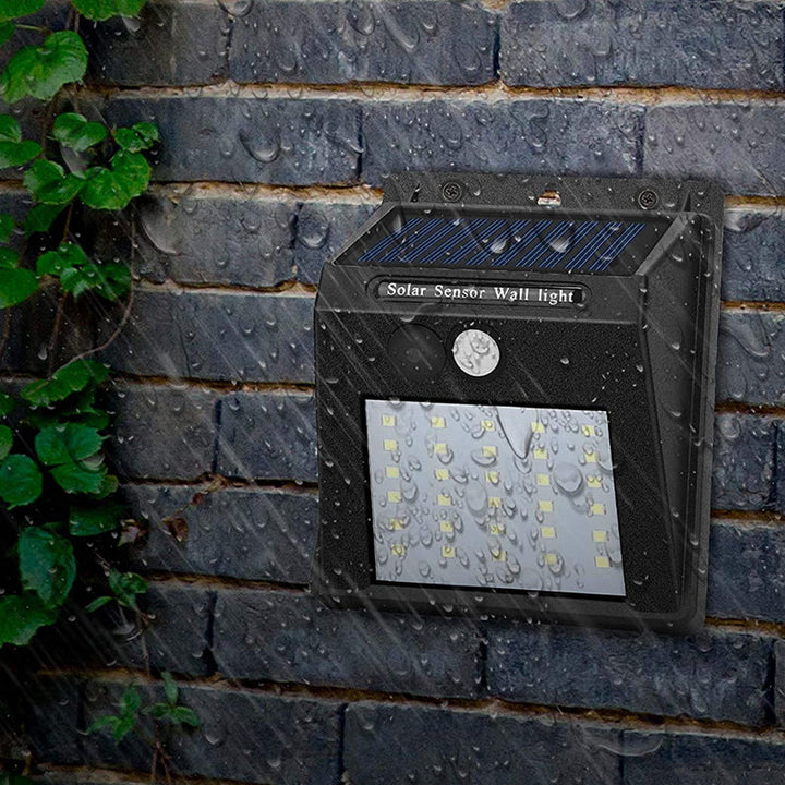 "Rörelsesensor LED-lampa utomhus IP65, solcellsdriven med 30 LED, robust svart design, perfekt för trädgårdsbelysning."