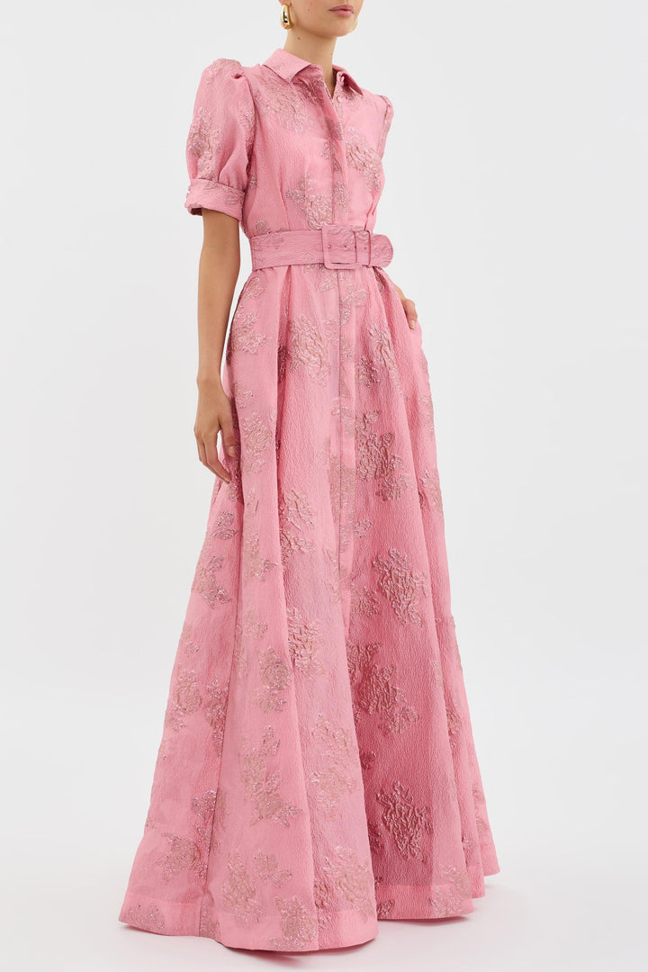 Detaljbild av elegant rosa damklänning med voluminösa puffärmar. En feminin midi sommar- och festklänning.