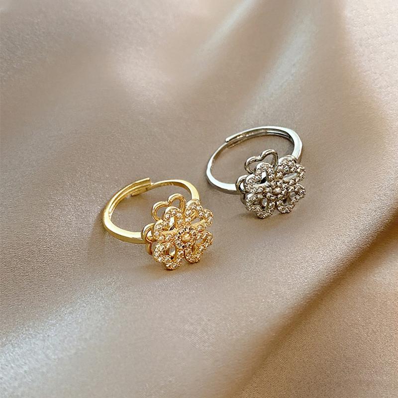 "Roterande fyrklöver ring för kvinnor, i silver eller guld med zirkonstenar, elegant design för modern stil."