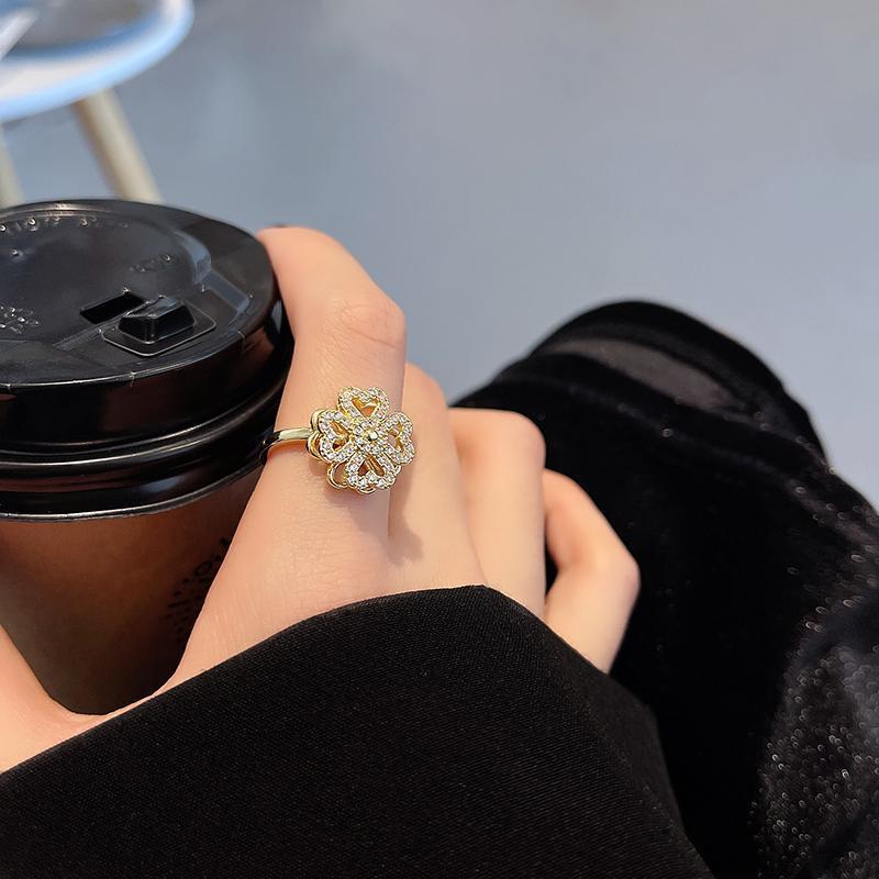 "Roterande fyrklöver ring för kvinnor, i silver eller guld med zirkonstenar, elegant design för modern stil."