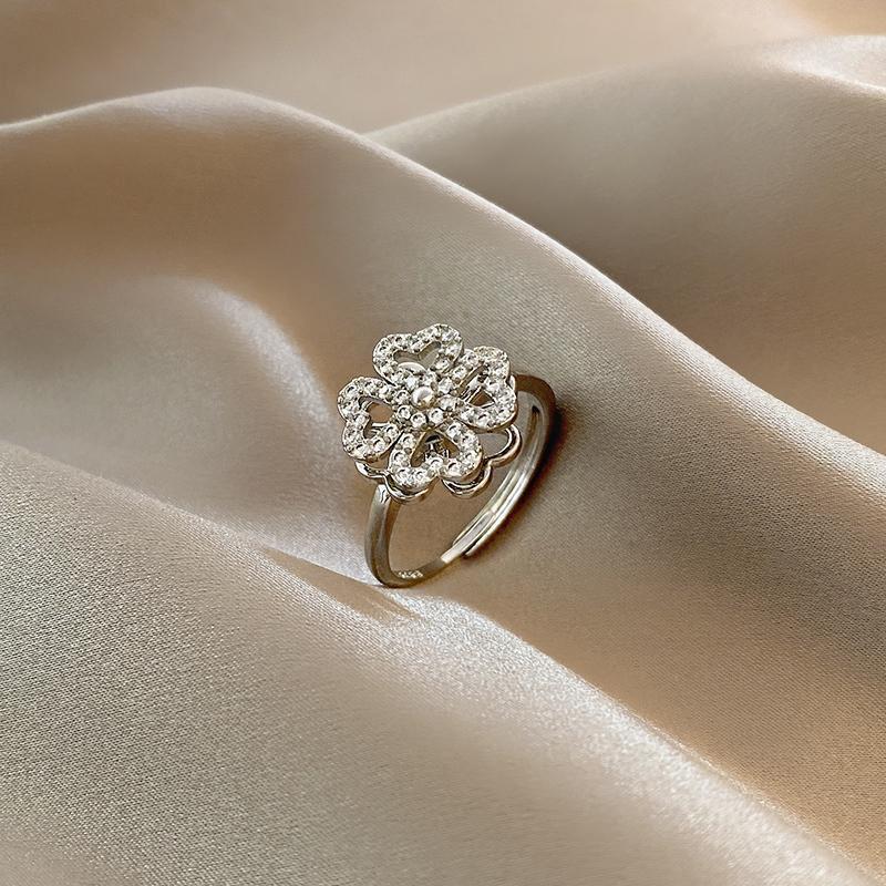 "Roterande fyrklöver ring för kvinnor, i silver eller guld med zirkonstenar, elegant design för modern stil."