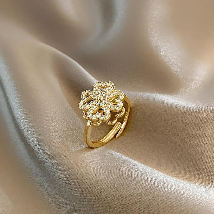 "Roterande fyrklöver ring för kvinnor, i silver eller guld med zirkonstenar, elegant design för modern stil."