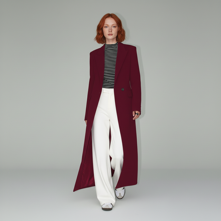 Modern figursydd damkappa i djupt rubinrött. Lång design med elegant fall och stilren look.