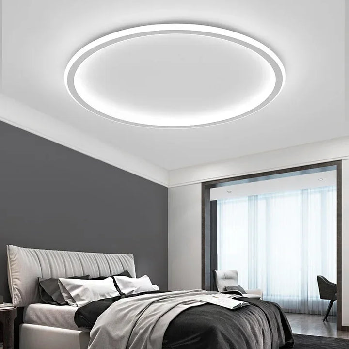 Vit rund LED taklampa med guld accent, minimalistisk och funktionell.