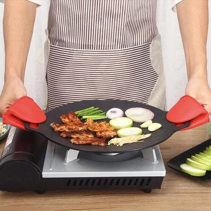 Rund non-stick stekpanna i svart aluminiumlegering med två öronhandtag, idealisk för grillmatlagning utomhus.
