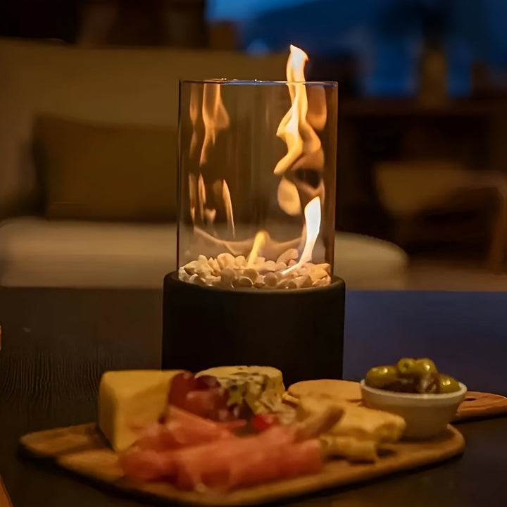 Rund rökfri bordseldstad i svart, perfekt för mysig inredning och atmosfär i vardagsrummet.