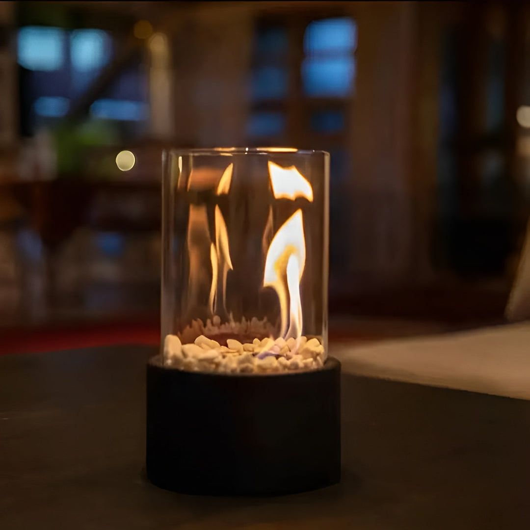 Närbild på flammande rökfri bordseldstad, betona mysig atmosfär och design i svart.