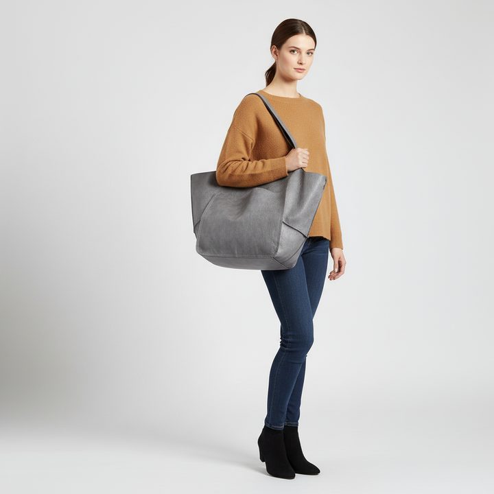 Kvinna bär elegant vegansk shopper. Rymlig axelremsväska i konstläder, perfekt för vardag.