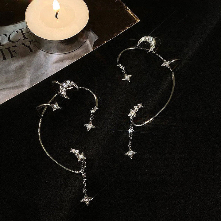 "Silver öronklämma med måne och stjärnor, elegant damaccessoar, zirkondetaljer som fångar ljuset."